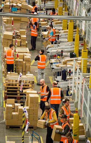 名亚马逊员工和临时工正在赫特福德郡的仓库中忙着准备和包装热卖产品